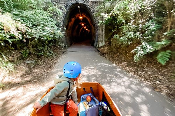 A family riding a Tribe Original cargo bike on a coastal path