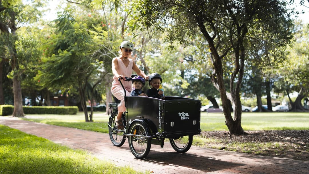 A family riding a Tribe Original cargo bike