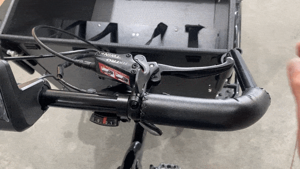 A rider squeezing the brake lever on a Tribe Original to engage the park brake